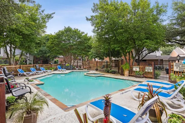a view of a swimming pool with lounge chairs in patio