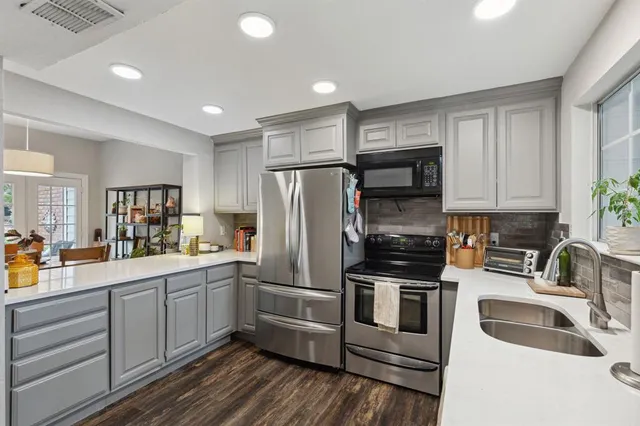 a kitchen with a sink stainless steel appliances and cabinets