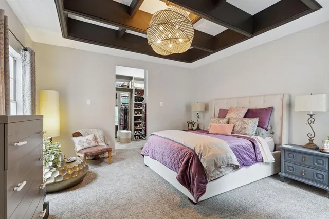 a spacious bedroom with a bed and a chandelier