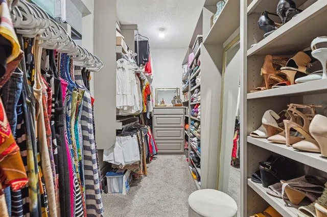 a view of walk in closet with clothes and shoes