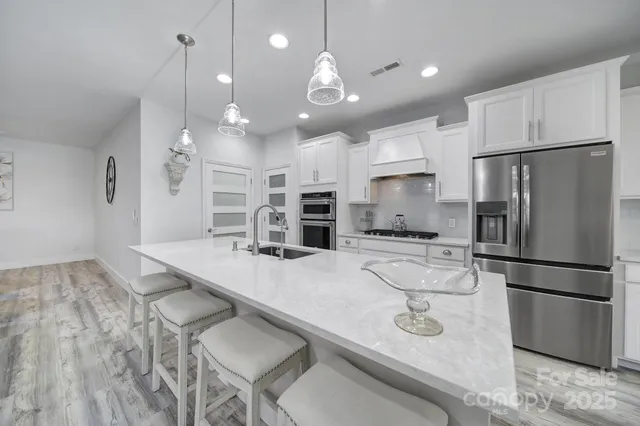 a kitchen with kitchen island a large counter top appliances and cabinets