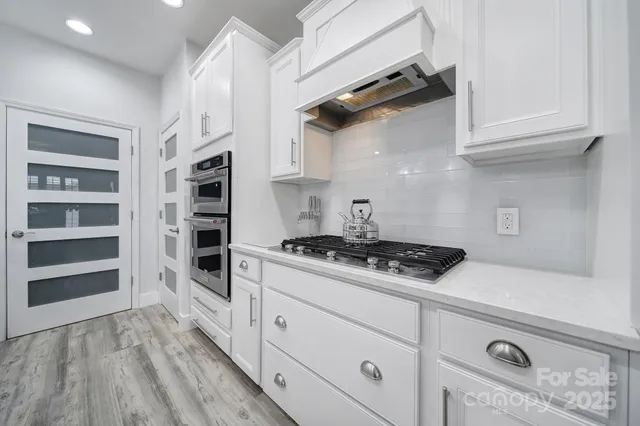 a kitchen with white cabinets and appliances