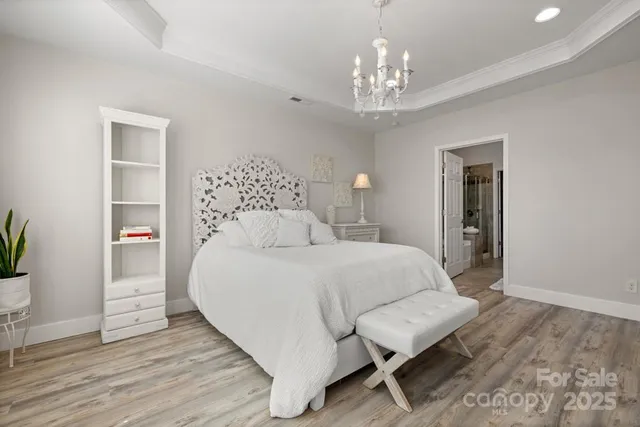 a bedroom with a bed and a chandelier