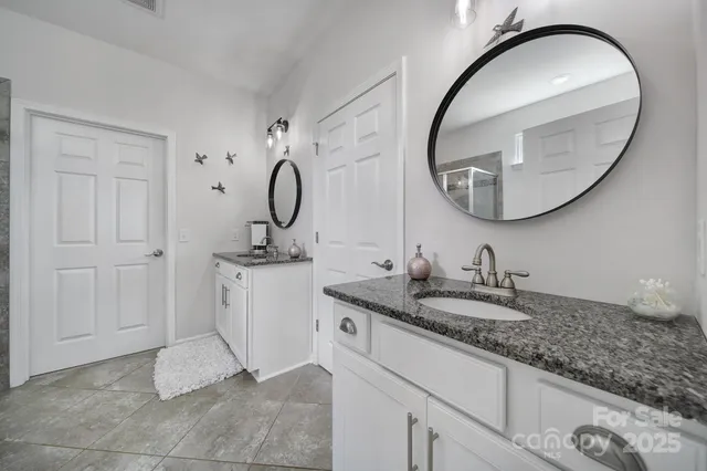 a bathroom with a granite countertop sink and a mirror