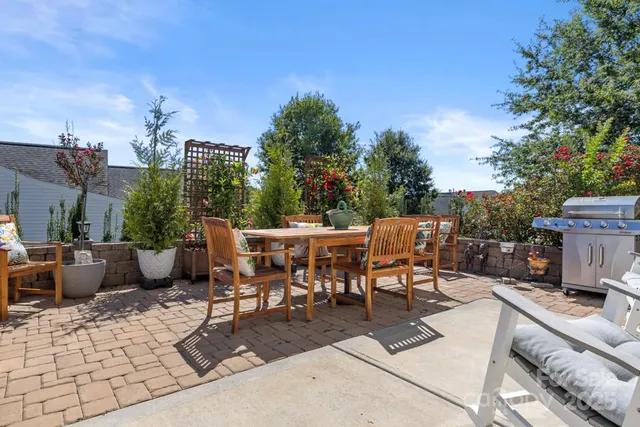 a view of a patio with a dining table and chairs with a fire pit