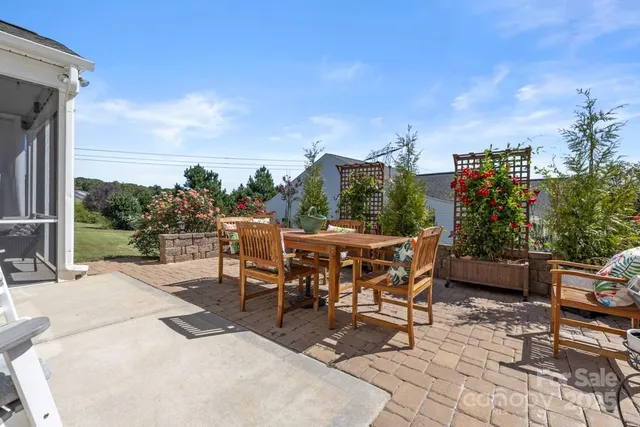 a view of a patio with a table and chairs and potted plants