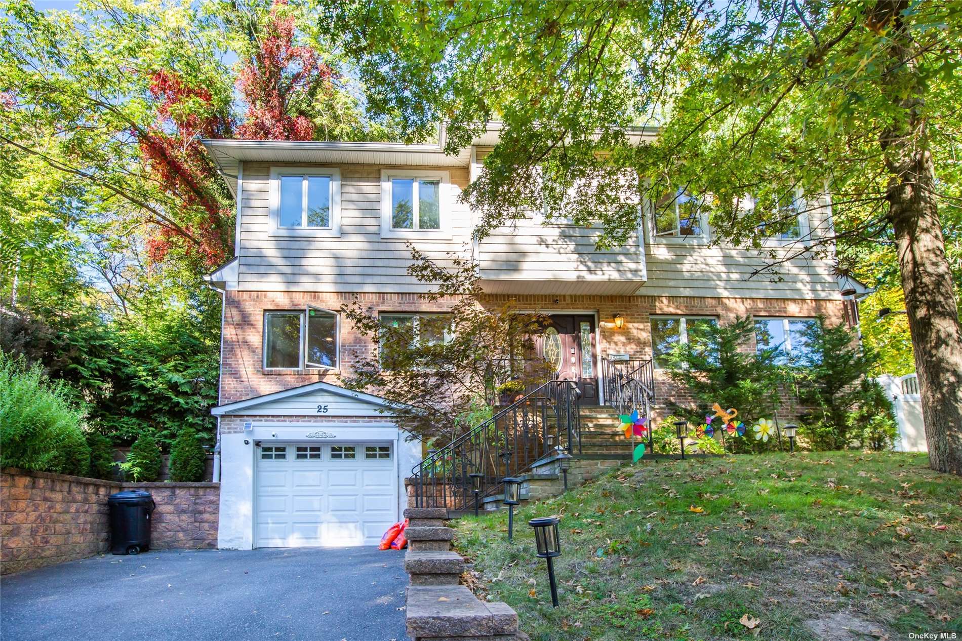 25 Ravine Road Great Neck, NY 11023 - Photo 1 of 1 a front view of a house with a yard and fountain in middle