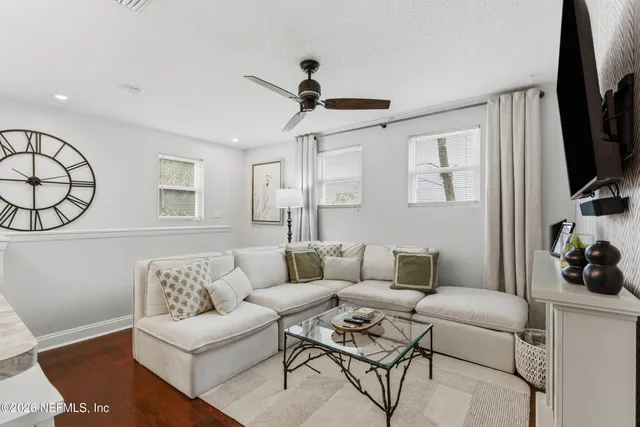 a living room with furniture a flat screen tv and a window