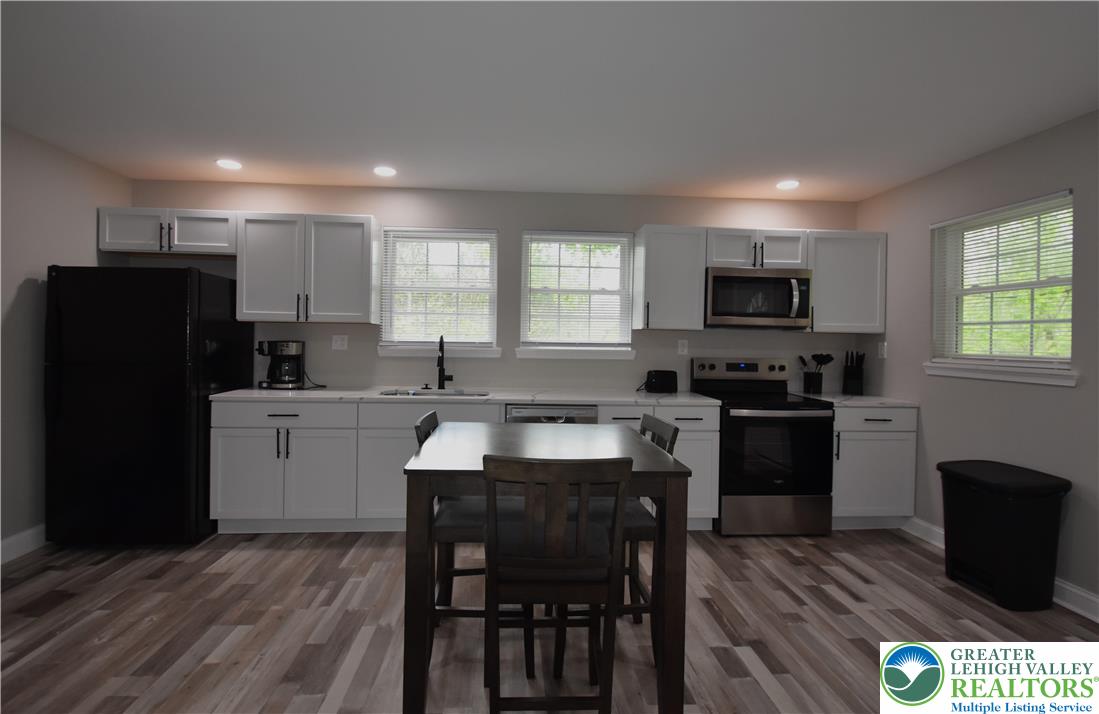 1500 Rock Street, Unit 1 Lehighton, PA 18235 - Photo 27 of 67 a kitchen with a refrigerator a stove a sink a dining table and chairs