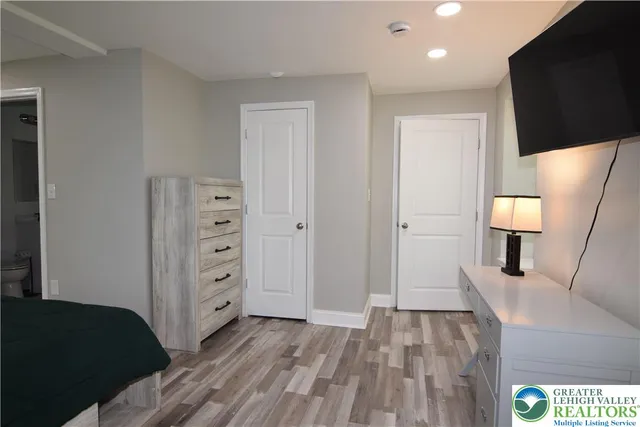 a bedroom with a bed and a flat screen tv