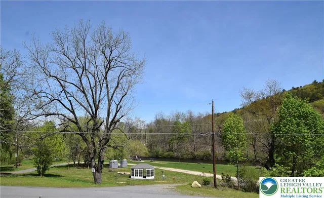a front view of a house with a tree