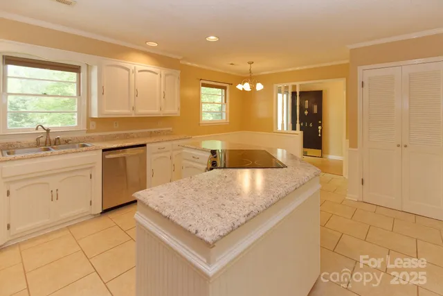 a kitchen with stainless steel appliances granite countertop a sink and dishwasher with white cabinets