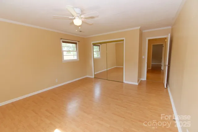 an empty room with fan and windows