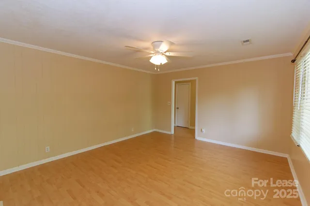 an empty room with a ceiling fan and a window