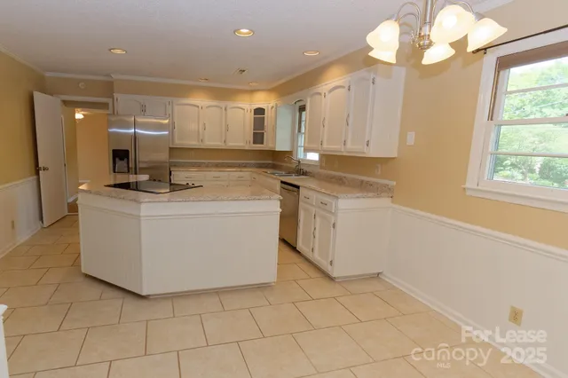 a kitchen with a sink a counter top space cabinets and stainless steel appliances