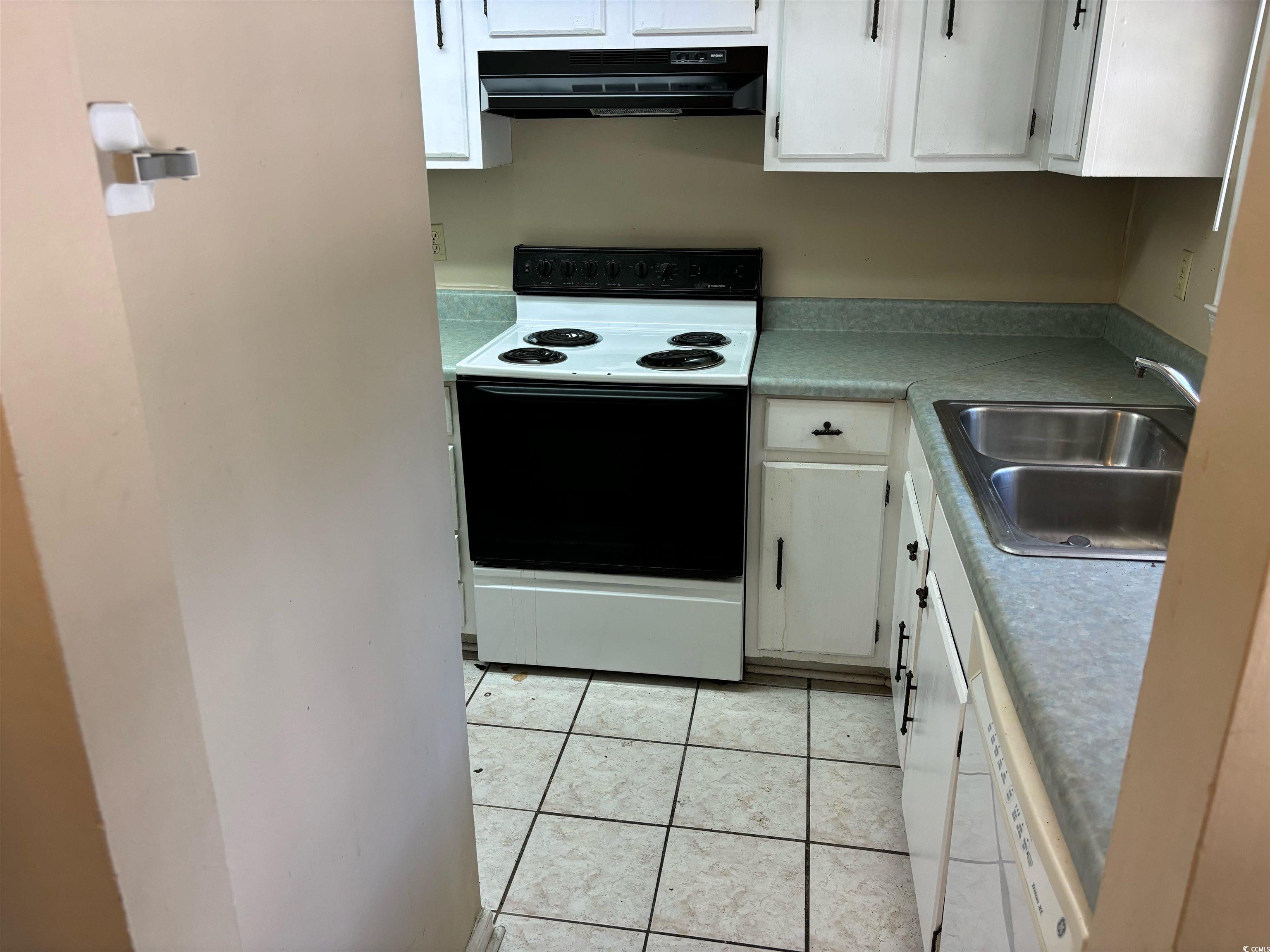 1025 Carolina Road, Unit G3 Conway, SC 29526 - Photo 5 of 11 Kitchen featuring light tile patterned floors, sink, white appliances, range hood, and white cabinetry