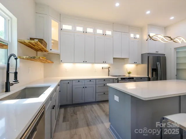 a kitchen with kitchen island granite countertop a sink stove and refrigerator
