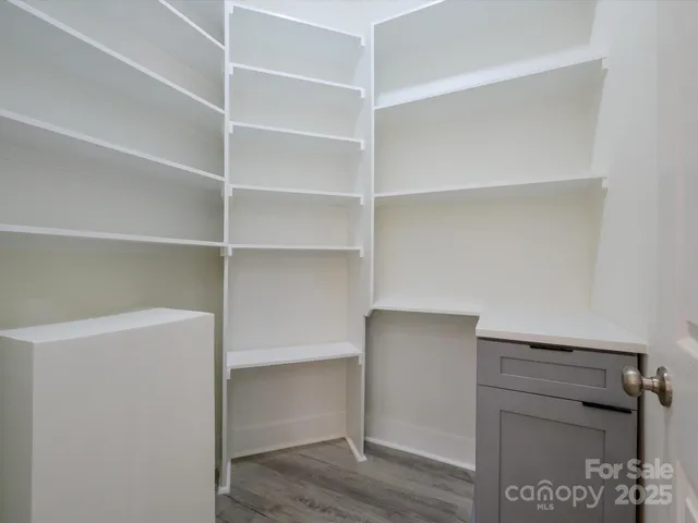 a view of walk in closet with empty racks