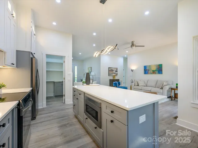 a large kitchen with stainless steel appliances a large counter top