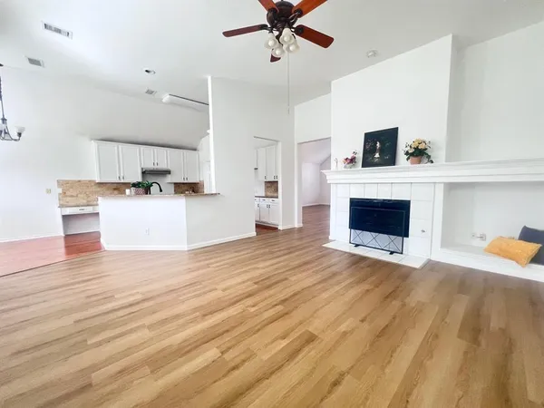 a view of empty room with a kitchen and fireplace