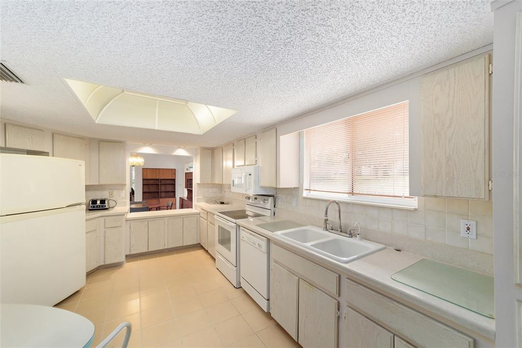 10984 Southwest 82nd Terrace Ocala, FL 34481 - Photo 13 of 40 a kitchen with a sink a stove a refrigerator and white cabinets