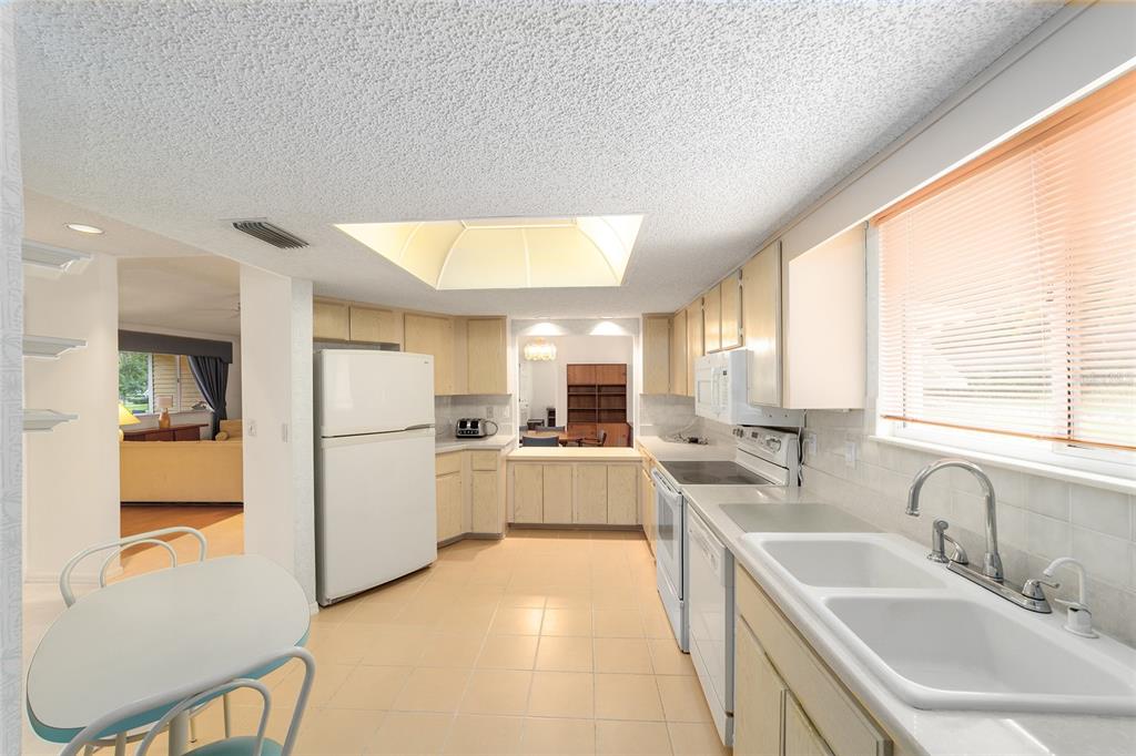 10984 Southwest 82nd Terrace Ocala, FL 34481 - Photo 14 of 40 a kitchen with a sink a counter top space stainless steel appliances cabinets and a large window