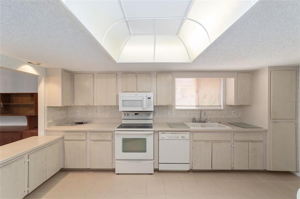 10984 Southwest 82nd Terrace Ocala, FL 34481 - Photo 16 of 40 a kitchen with white cabinets appliances and a window
