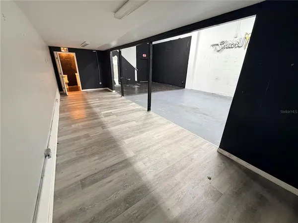 a view of a hallway with wooden floor and a couch