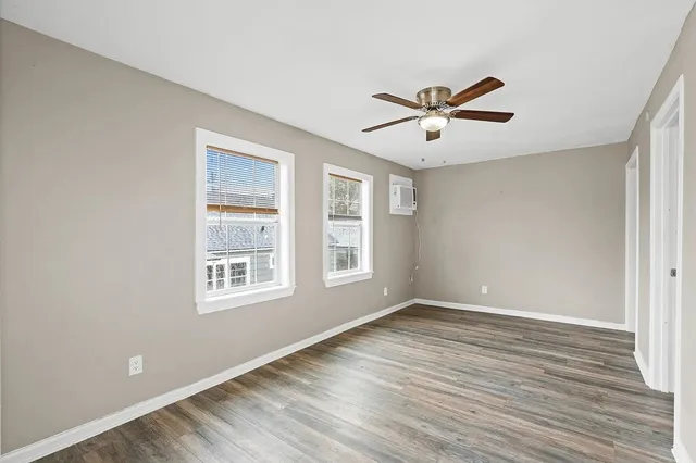 a view of a room with wooden floor and chandelier fan