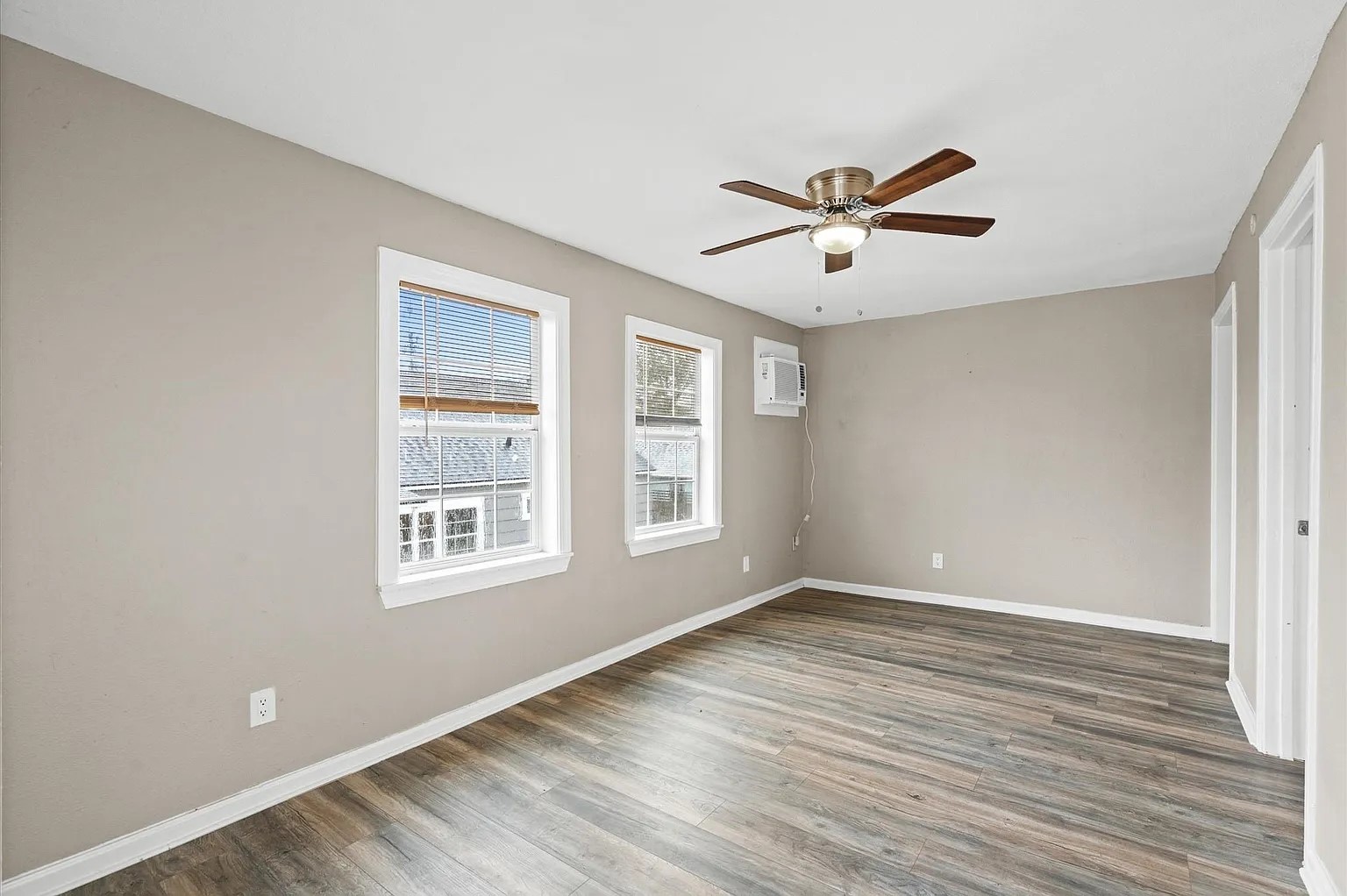 a view of a room with wooden floor and chandelier fan