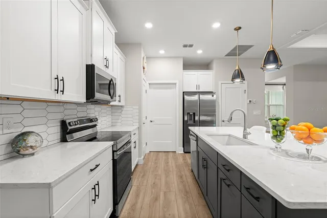 a kitchen with stainless steel appliances a sink stove and refrigerator