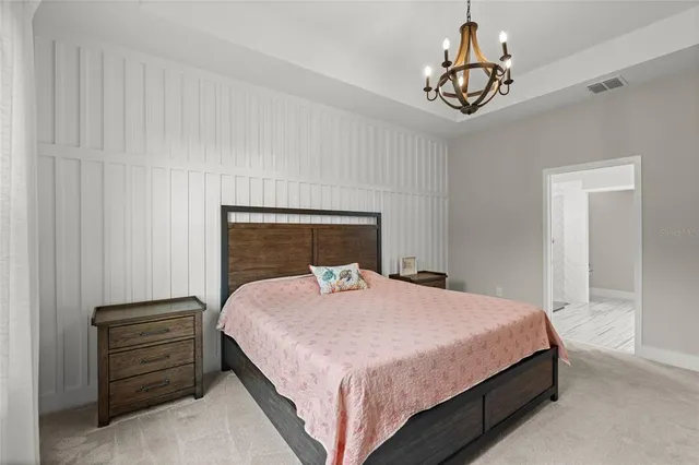 a bedroom with a bed and a chandelier