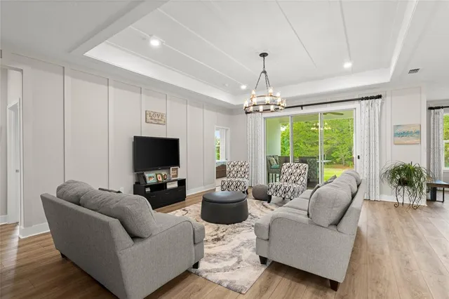a living room with furniture a flat screen tv and a large window