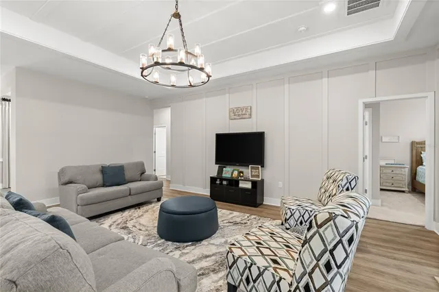 a living room with furniture a flat screen tv and kitchen view