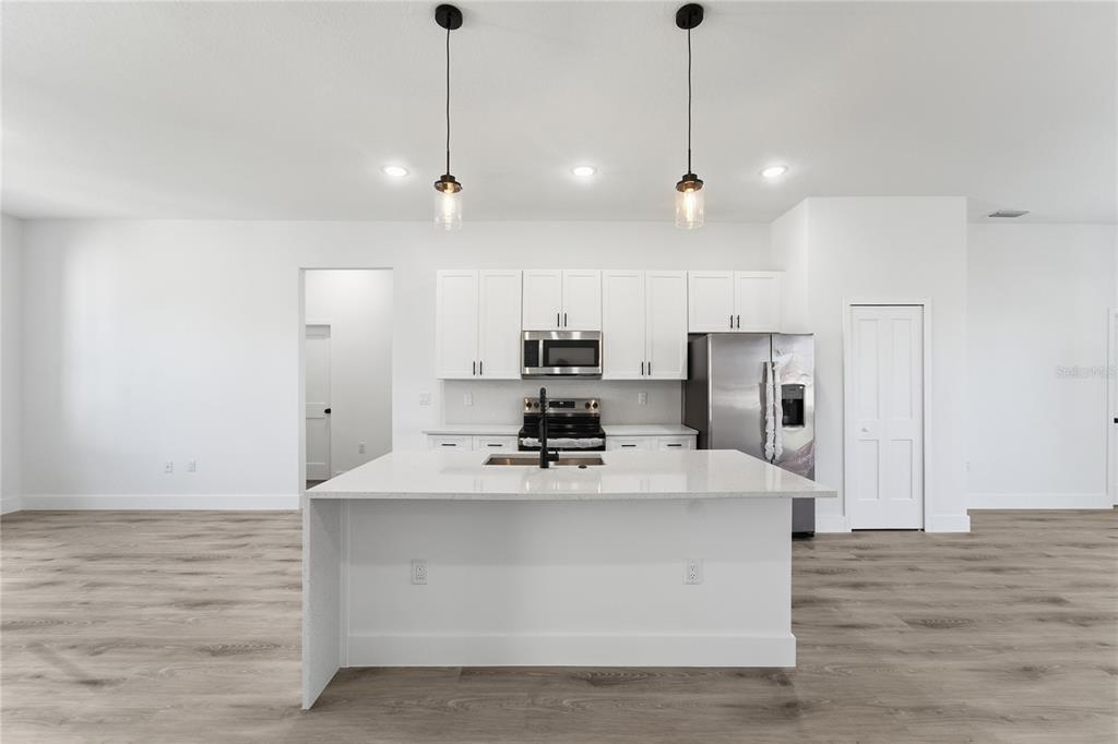 2600 Southwest 146th Pl Road Ocala, FL 34473 - Photo 38 of 40 a kitchen with kitchen island a sink stainless steel appliances and wooden floor
