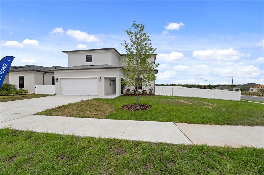 6308 Chorus Drive Mascotte, FL 34753 - Photo 2 of 24 a front view of a house with a garden and yard