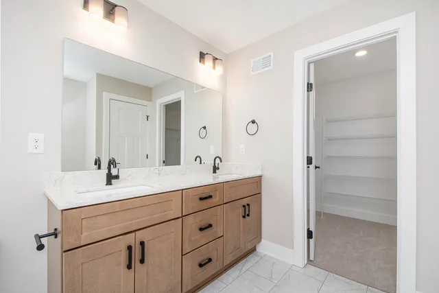 a bathroom with a double vanity sink and mirror