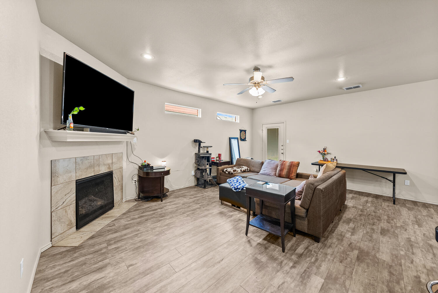 2128 10th Street Lubbock, TX 79401 - Photo 3 of 23 a living room with furniture a flat screen tv and a fireplace