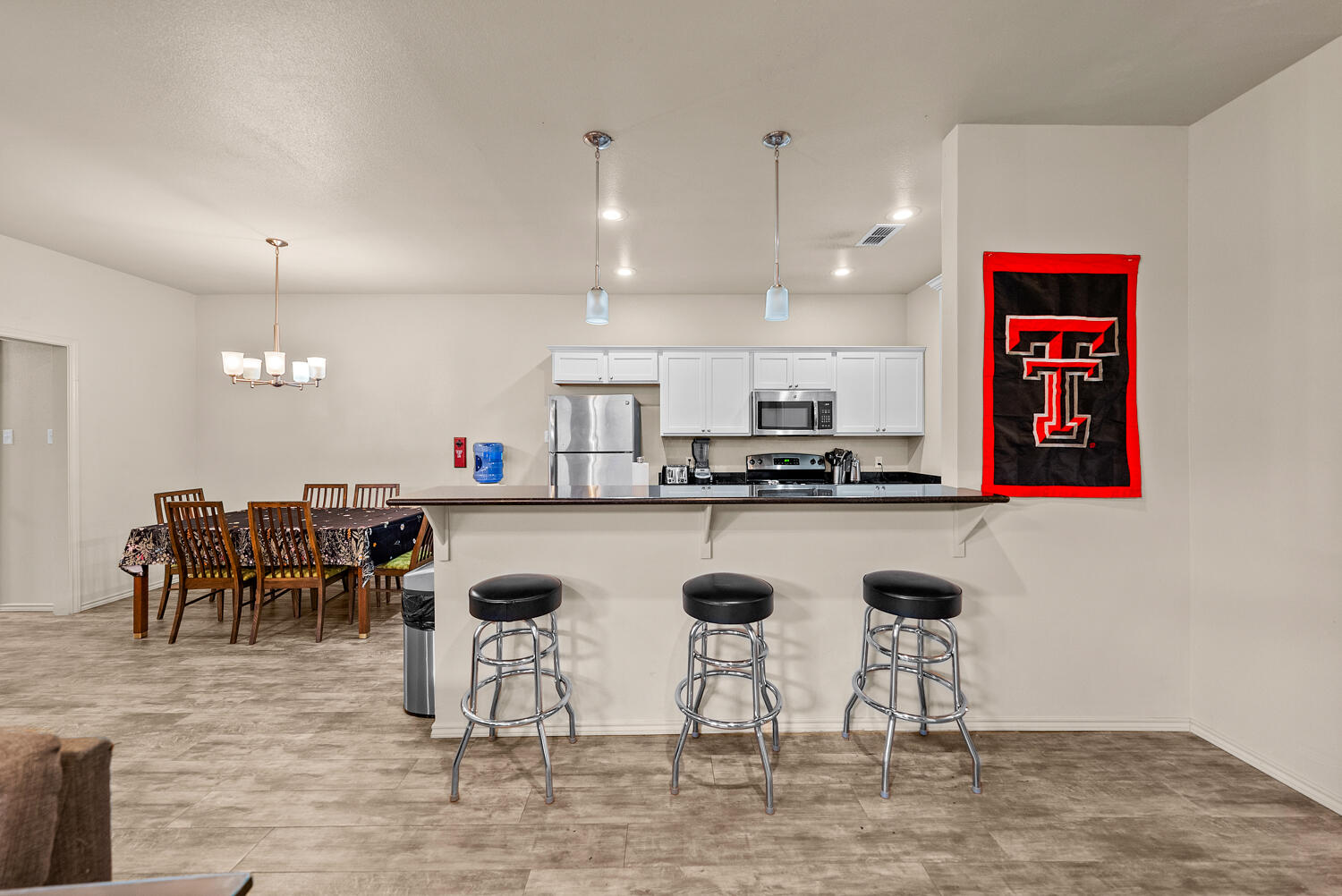 2128 10th Street Lubbock, TX 79401 - Photo 5 of 23 a kitchen with stainless steel appliances kitchen island granite countertop a table and chairs in it