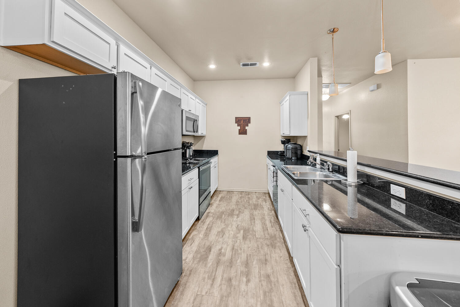 2128 10th Street Lubbock, TX 79401 - Photo 6 of 23 a large kitchen with stainless steel appliances a refrigerator and a sink