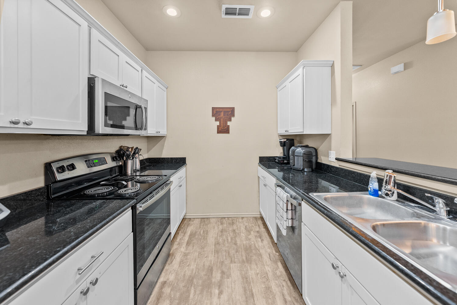 2128 10th Street Lubbock, TX 79401 - Photo 7 of 23 a kitchen with stainless steel appliances granite countertop a sink stove and cabinets
