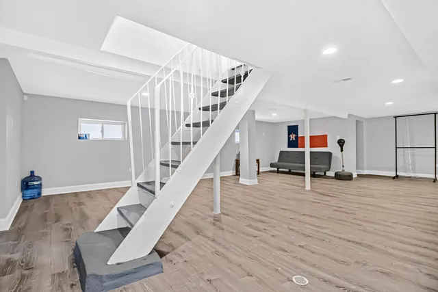 a view of a livingroom with wooden floor and stairs