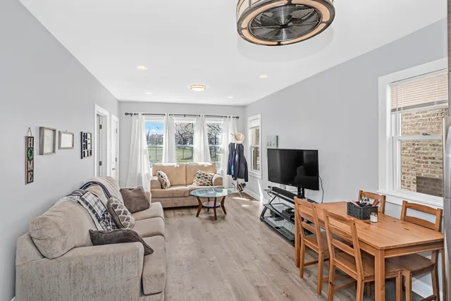 a living room with furniture a flat screen tv and a window
