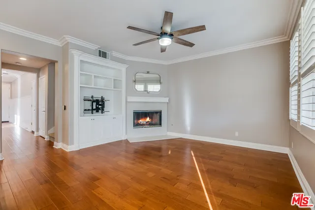 a view of an empty room with a window and fireplace