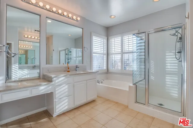 a spacious bathroom with a double vanity sink a mirror and a bathtub