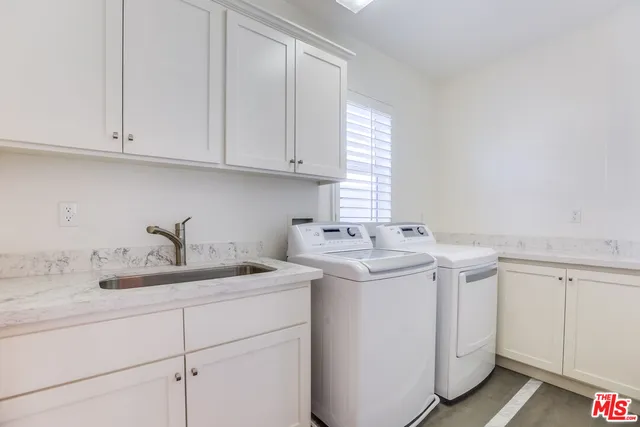 a utility room with sink dryer and washer