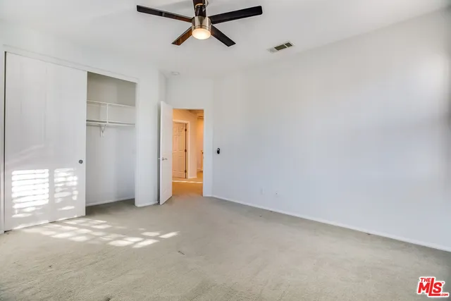 an empty room with closet and windows