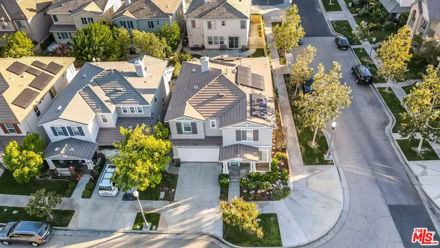 an aerial view of residential houses with outdoor space and trees