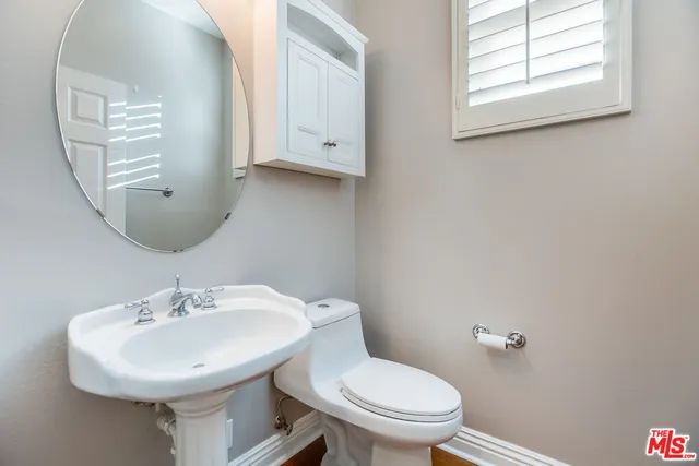 a bathroom with a toilet a sink and mirror