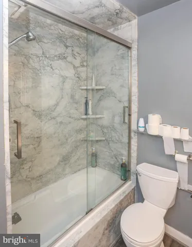 a white toilet sitting next to a bath tub and a shower